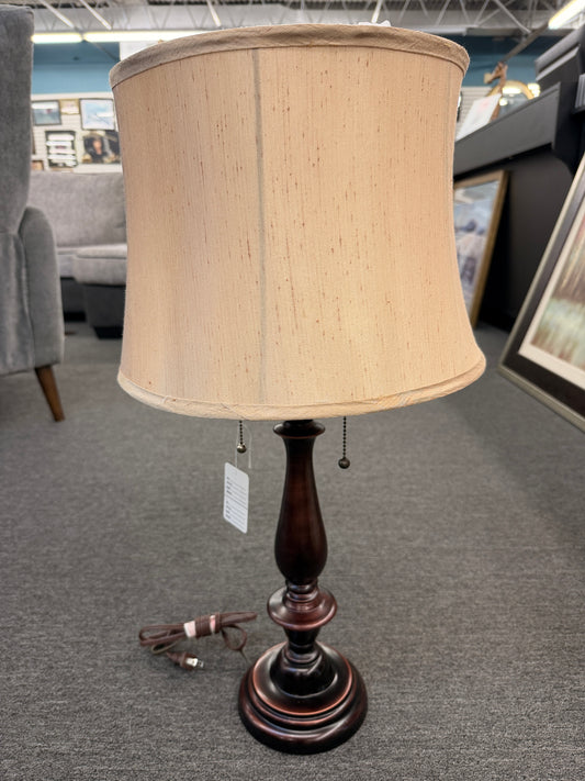 A classic accent table lamp featuring an oil-rubbed bronze turned-pedestal base, dual pull-chain switches, and a flared textured beige fabric shade in good condition.