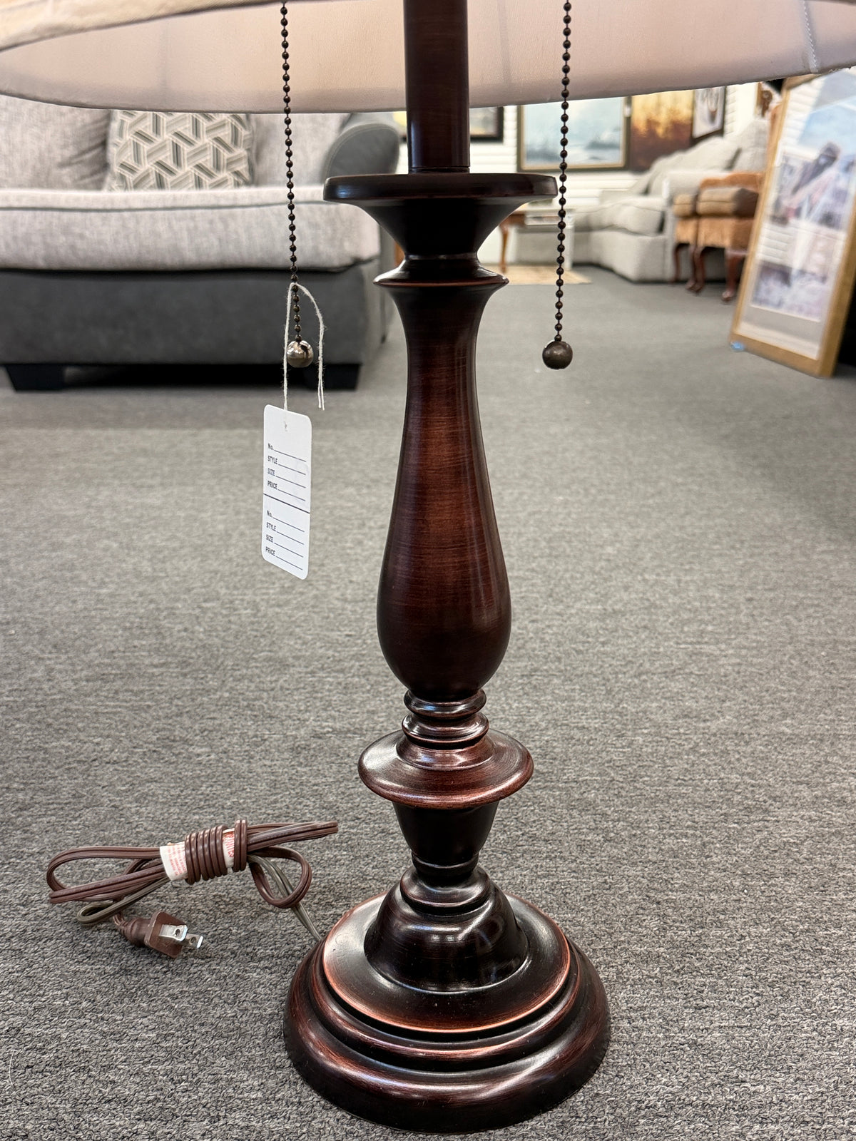 A classic accent table lamp featuring an oil-rubbed bronze turned-pedestal base, dual pull-chain switches, and a flared textured beige fabric shade in good condition.
