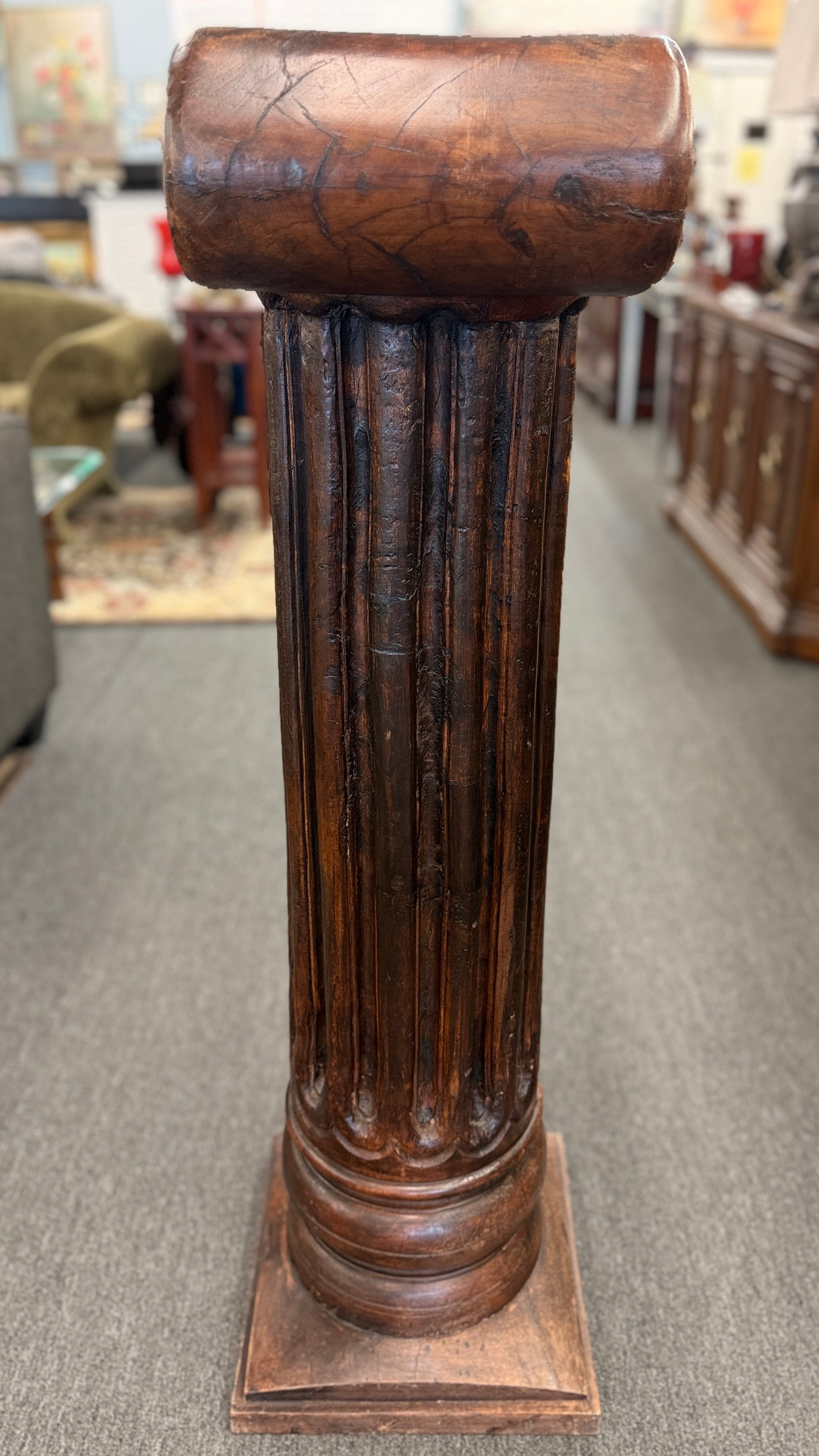 A classical wooden architectural pedestal featuring a carved Ionic scroll capital with floral motifs, a fluted shaft, and a square plinth base in excellent condition.