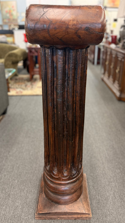 A classical wooden architectural pedestal featuring a carved Ionic scroll capital with floral motifs, a fluted shaft, and a square plinth base in excellent condition.