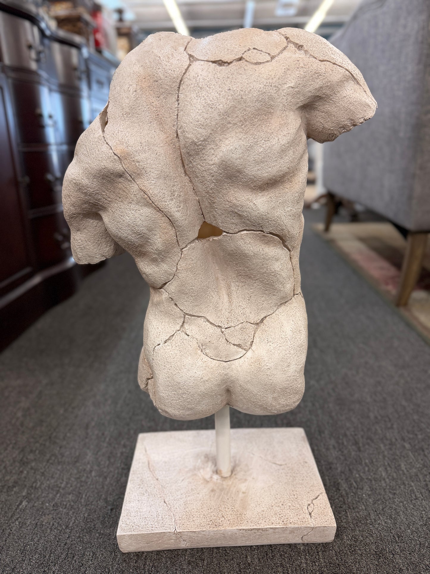 Classical-style male torso sculpture with a distressed stone-look finish, realistic crackled detailing, and a square display base.
