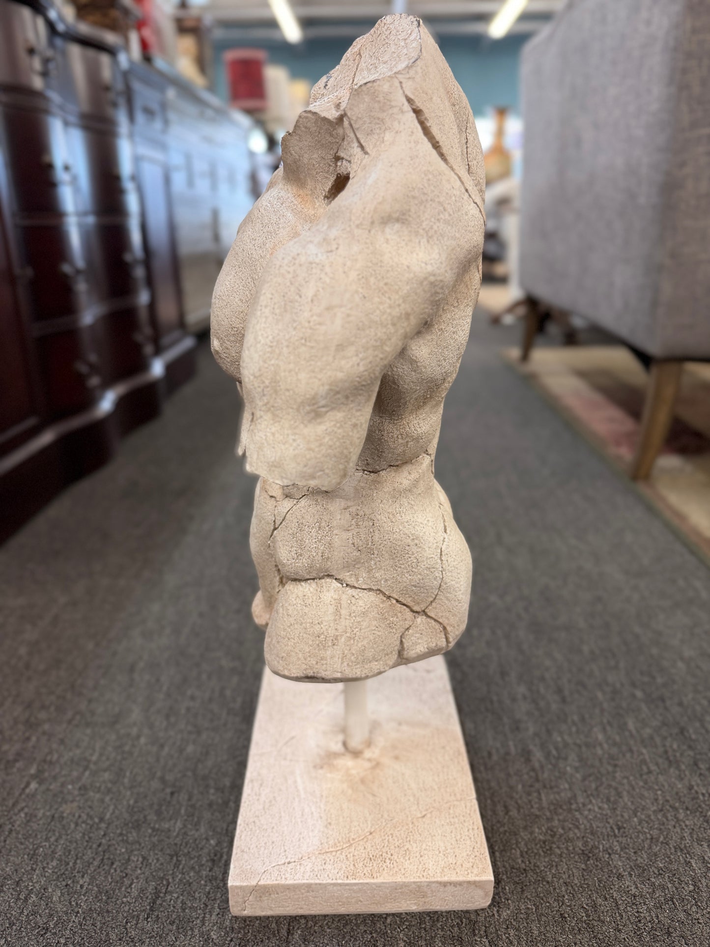 Classical-style male torso sculpture with a distressed stone-look finish, realistic crackled detailing, and a square display base.