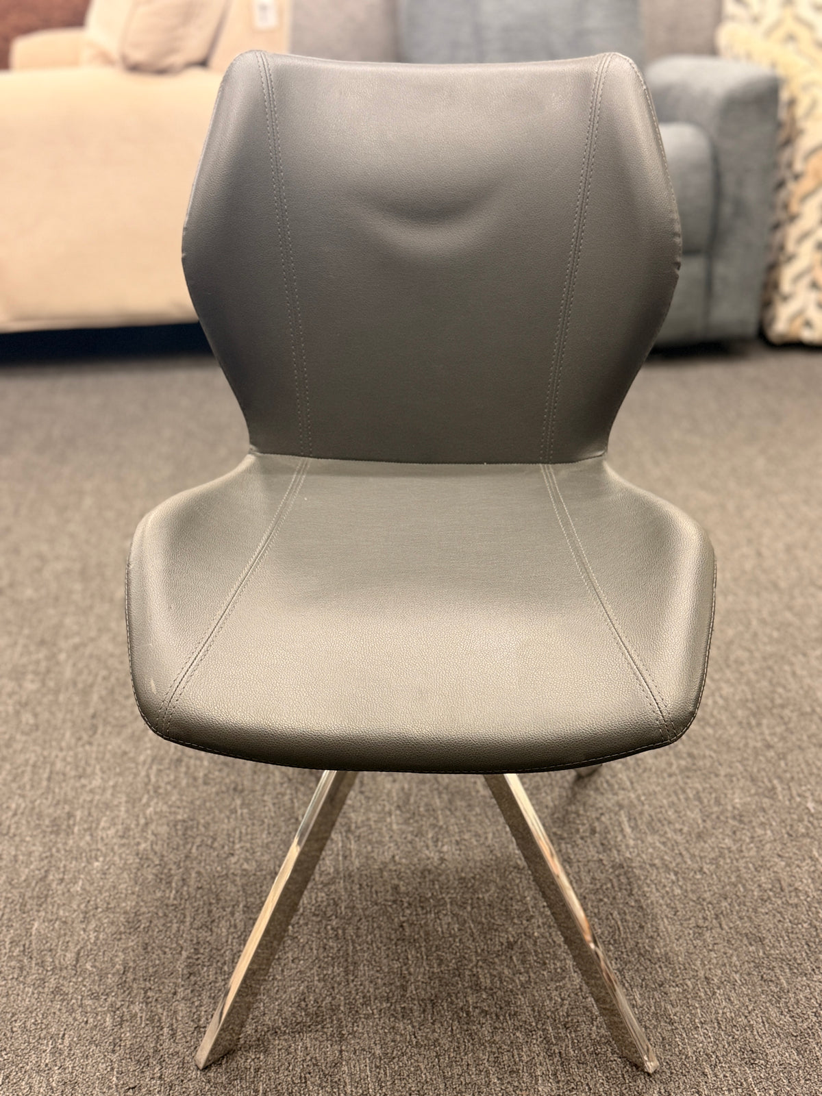 An accent office chair featuring sleek charcoal-gray faux leather upholstery with stitched seams, set on four angled chrome legs in good condition.