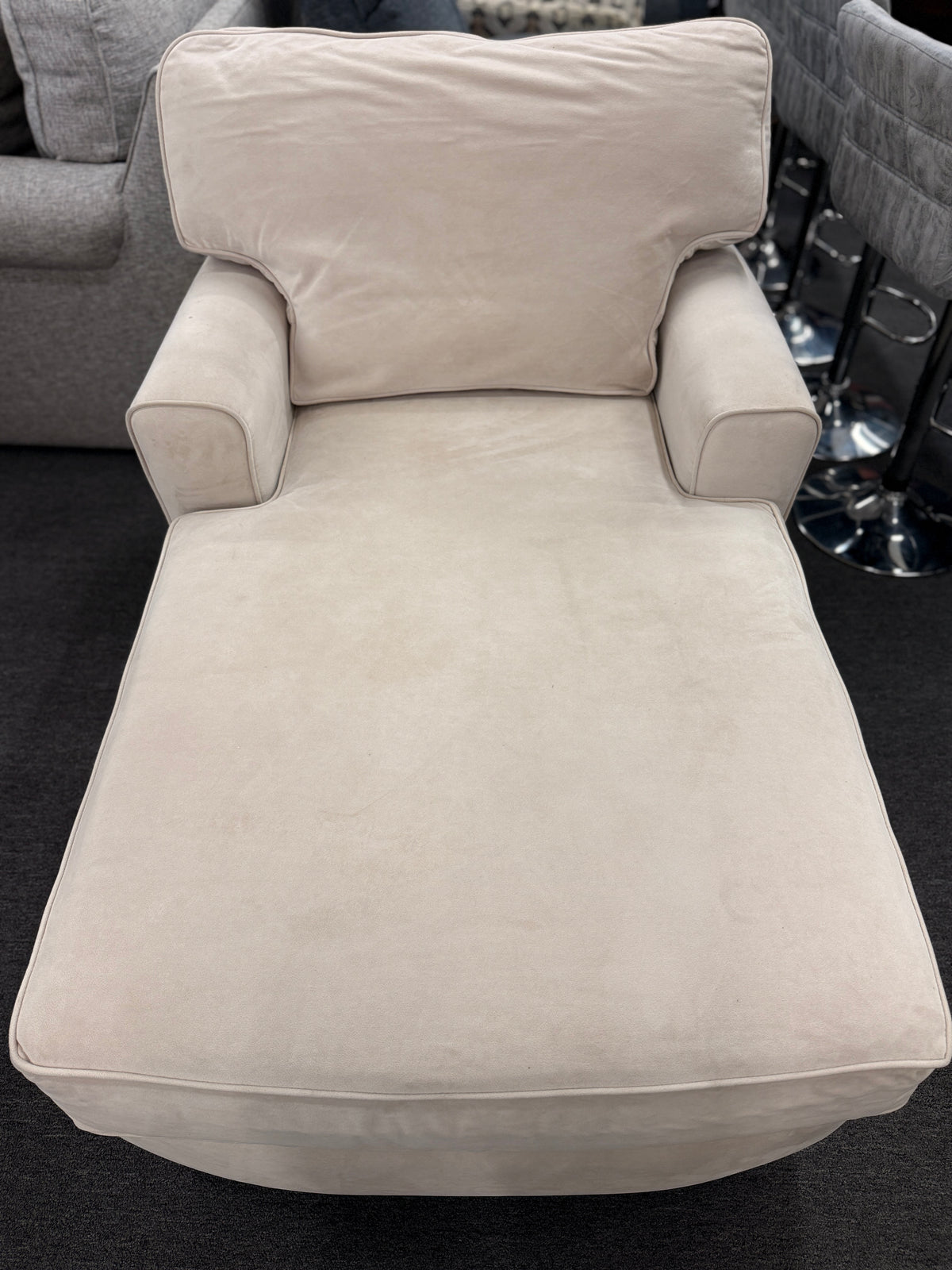 A contemporary single-seat chaise lounge upholstered in plush cream microfiber with track arms and a back cushion in good condition.