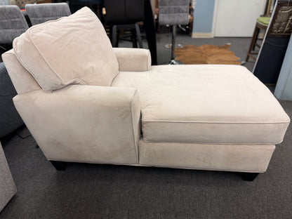 A contemporary single-seat chaise lounge upholstered in plush cream microfiber with track arms and a back cushion in good condition.