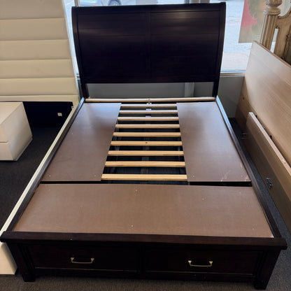 A contemporary dark-finished queen bed frame featuring a simple paneled headboard, wooden slat support, and two built-in storage drawers in the footboard.