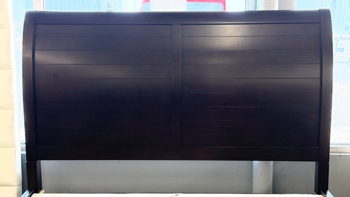 A contemporary dark-finished queen bed frame featuring a simple paneled headboard, wooden slat support, and two built-in storage drawers in the footboard.