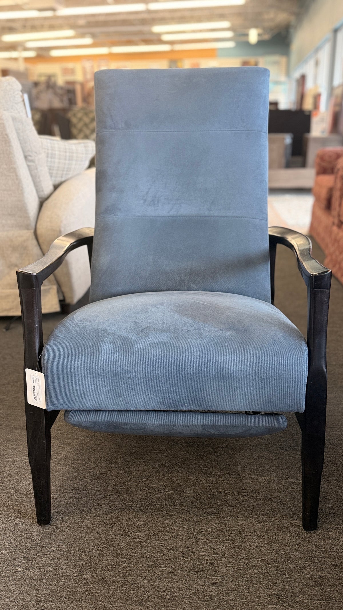 A contemporary high-back recliner upholstered in slate-blue textured fabric framed by slim contoured dark-wood armrests in excellent condition.