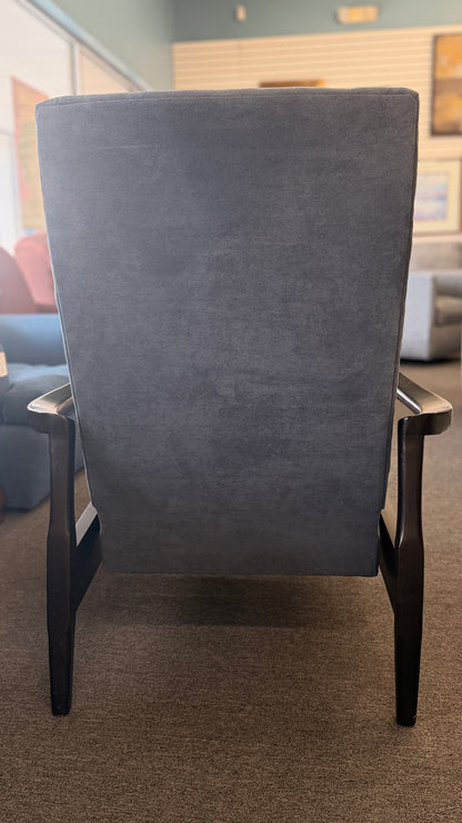 A contemporary high-back recliner upholstered in slate-blue textured fabric framed by slim contoured dark-wood armrests in excellent condition.