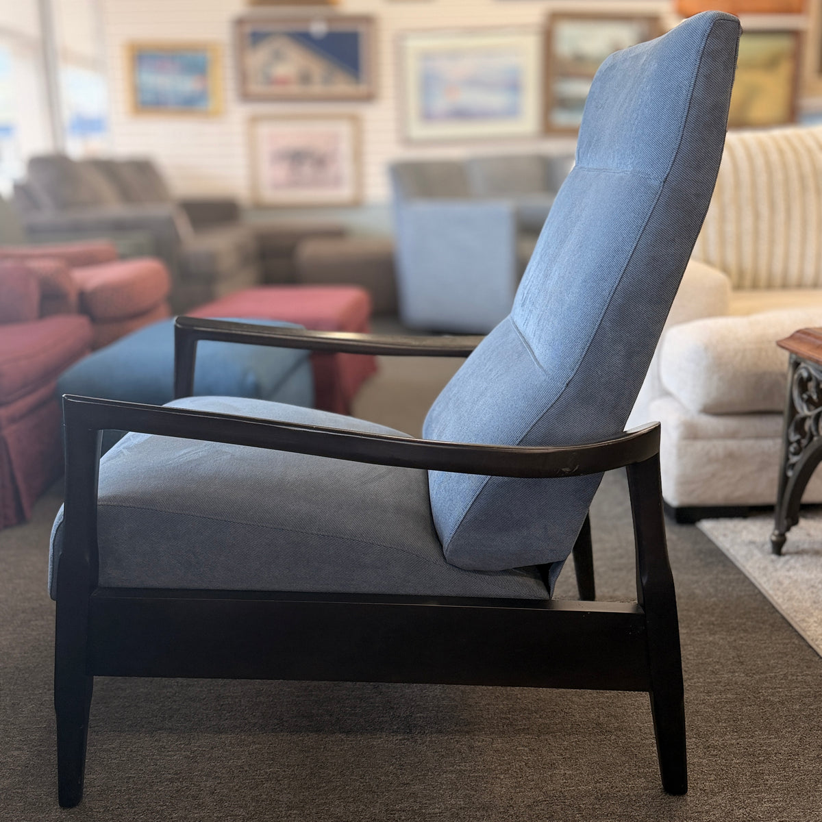 A contemporary high-back recliner upholstered in slate-blue textured fabric framed by slim contoured dark-wood armrests in excellent condition.