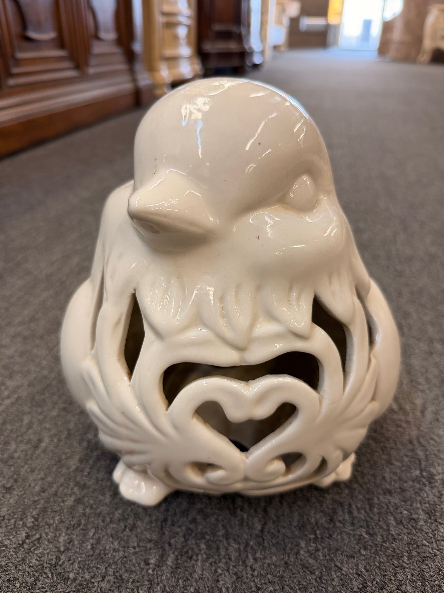 A cream glazed ceramic bird figurine featuring decorative openwork cutout hearts designed to hold a tealight or small candle in excellent condition.