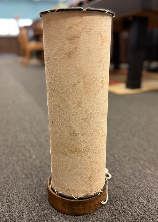 A cylindrical pergamino lamp featuring a textured parchment-style shade resting on a small dark wooden base in excellent condition.