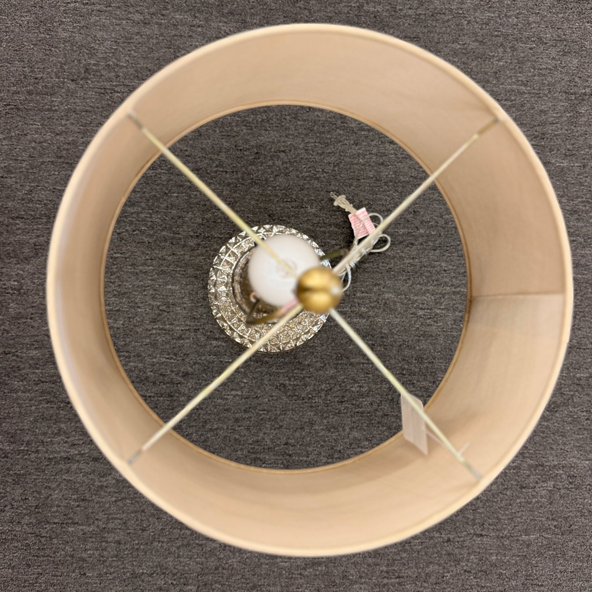 A modern transitional accent lamp featuring a diamond-quilted tinted glass urn base on a brass platform with a beige linen drum shade.