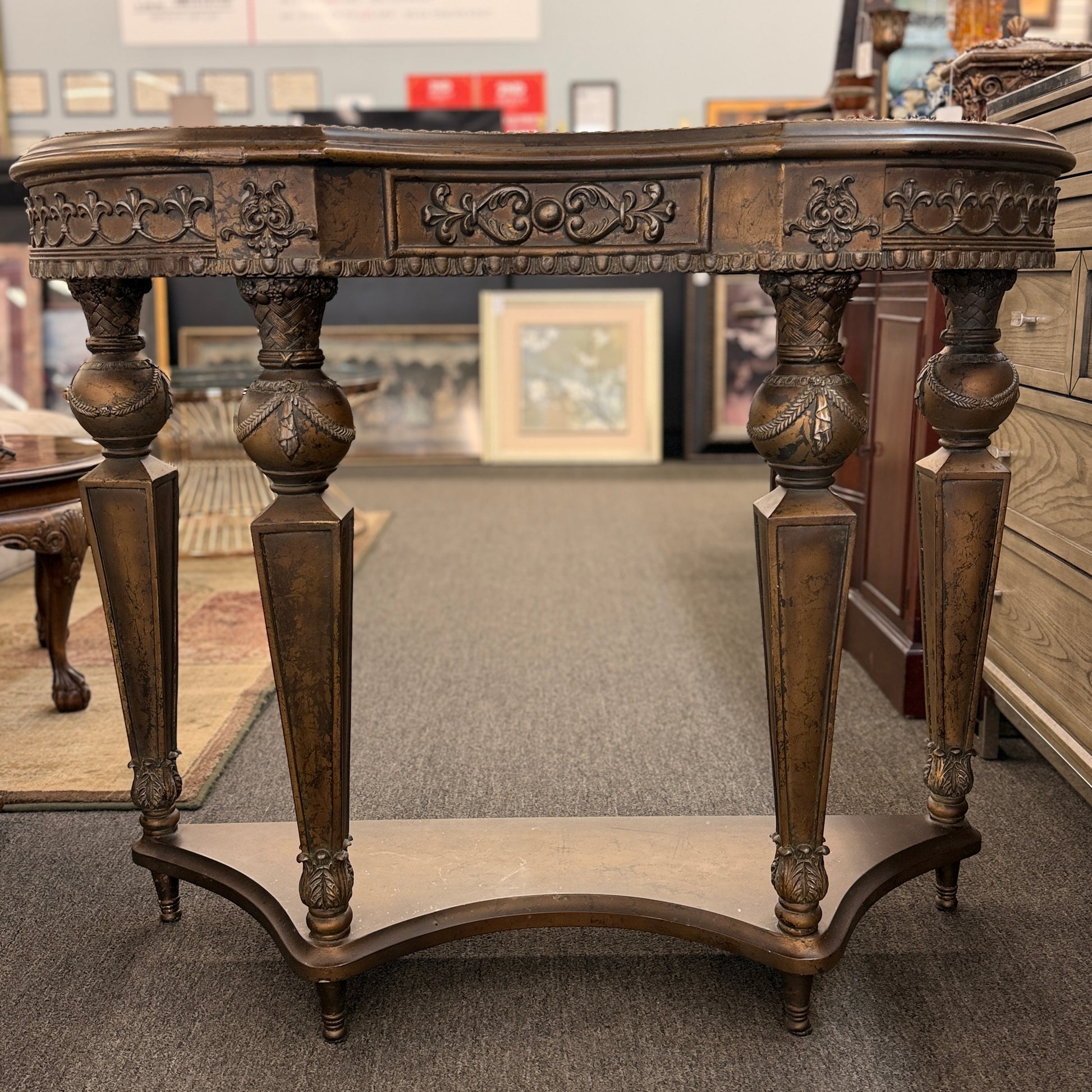 Distressed wood console table featuring ornate carved details, a center drawer, sculpted legs, and a gracefully curved lower stretcher.