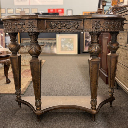 Distressed wood console table featuring ornate carved details, a center drawer, sculpted legs, and a gracefully curved lower stretcher.