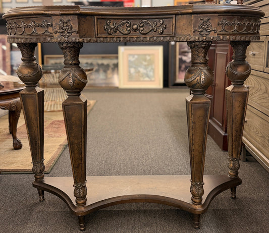 Distressed wood console table featuring ornate carved details, a center drawer, sculpted legs, and a gracefully curved lower stretcher.