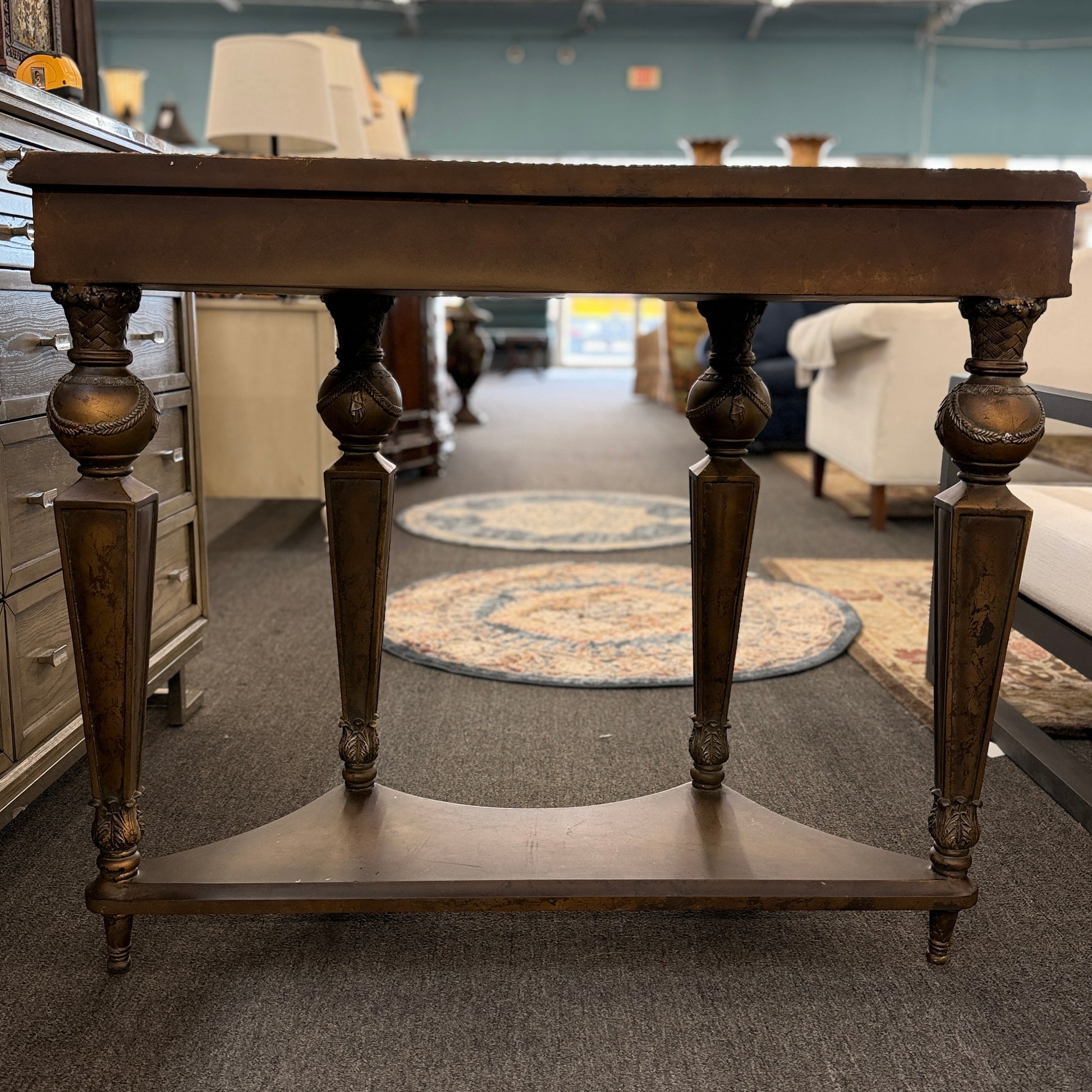 Distressed wood console table featuring ornate carved details, a center drawer, sculpted legs, and a gracefully curved lower stretcher.