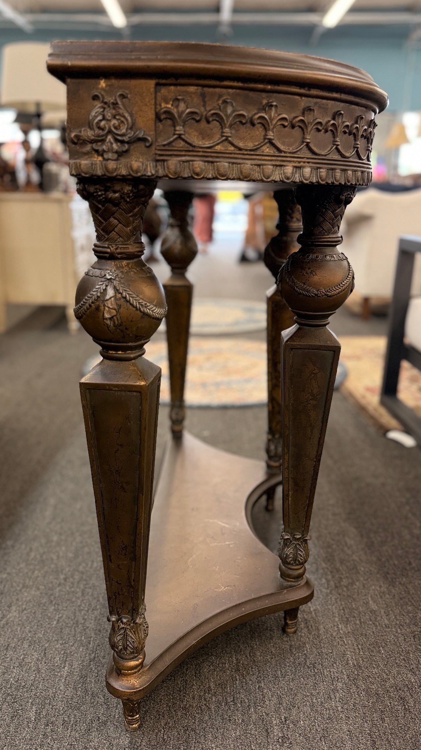 Distressed wood console table featuring ornate carved details, a center drawer, sculpted legs, and a gracefully curved lower stretcher.