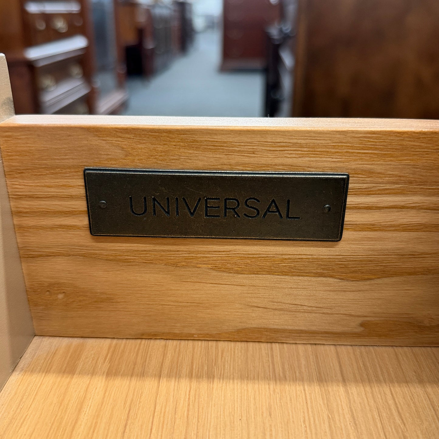 Distressed wood four-drawer chest featuring raised geometric drawer fronts, dark octagonal ring pulls, and a light washed finish.