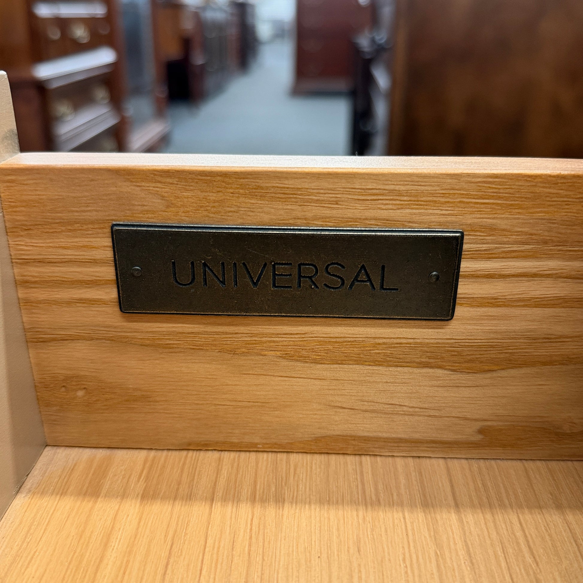 Distressed wood four-drawer chest featuring raised geometric drawer fronts, dark octagonal ring pulls, and a light washed finish.
