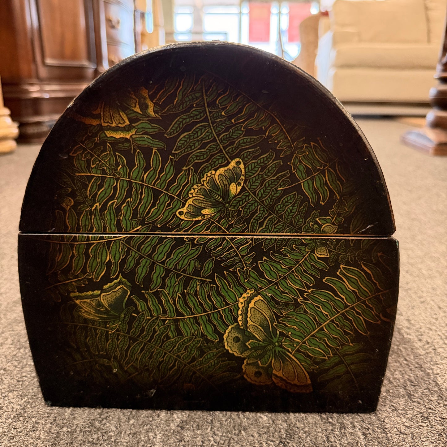 A small domed-top wooden treasure chest featuring green fern patterns, gold butterfly motifs, a metal swing clasp, and top handle in good condition.
