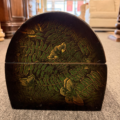 A small domed-top wooden treasure chest featuring green fern patterns, gold butterfly motifs, a metal swing clasp, and top handle in good condition.