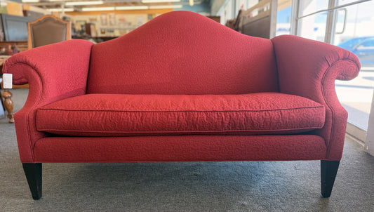 A bright red upholstered Ethan Allen loveseat with a subtly patterned fabric, curved backrest, and dark tapered legs in good condition.