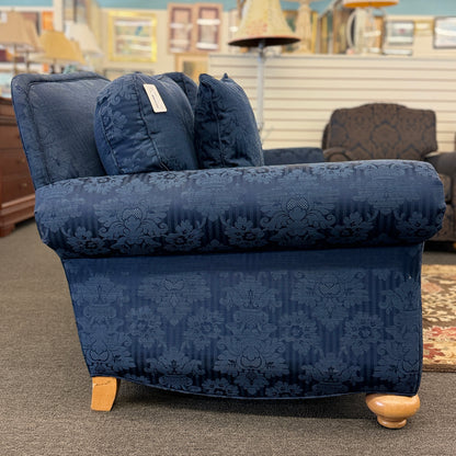 Traditional Ethan Allen three-seater sofa upholstered in blue tone-on-tone damask fabric with English rolled arms, three seat cushions, three back cushions, two matching accent pillows, and turned wooden bun feet.