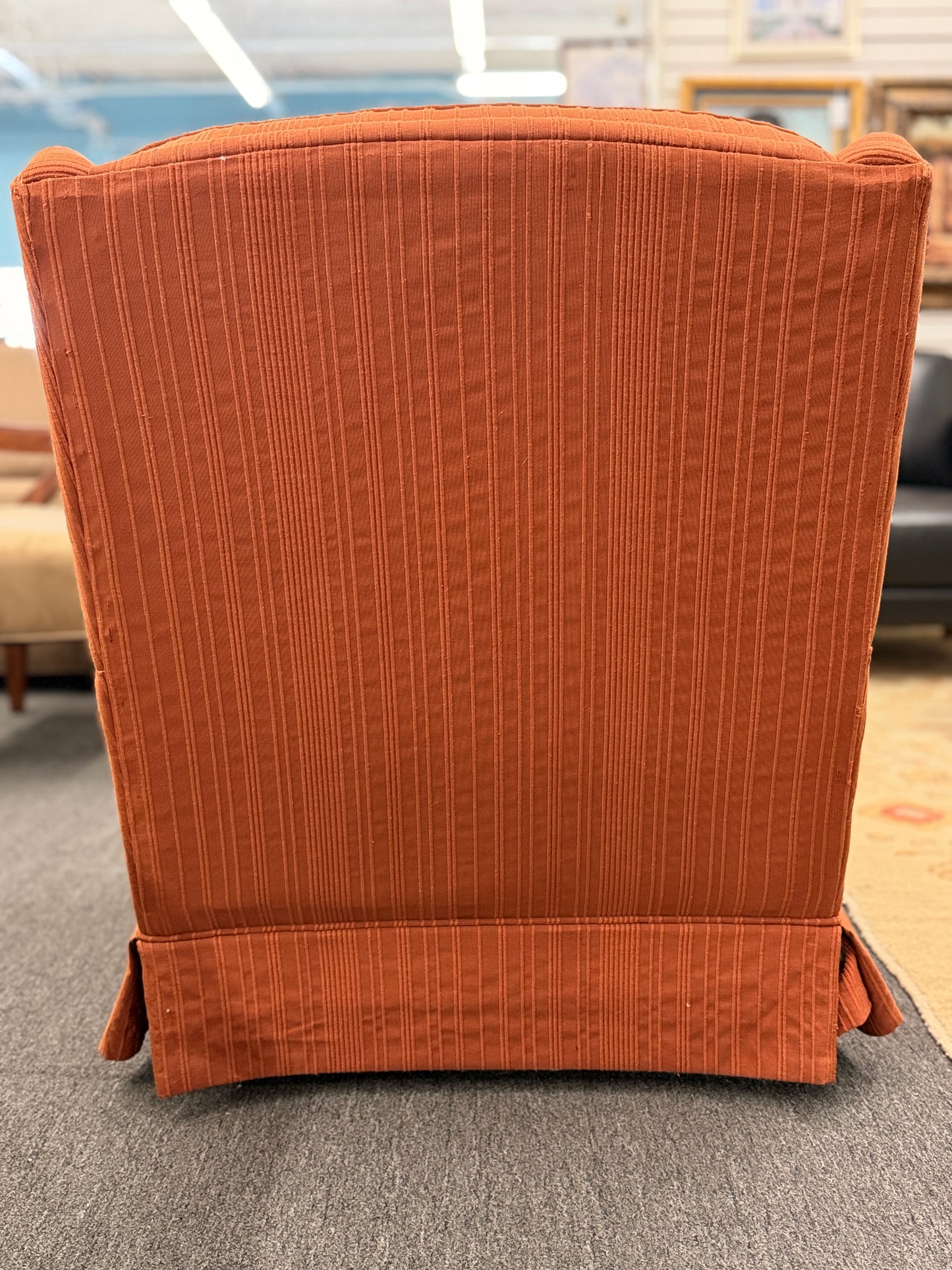 Ethan Allen upholstered armchair featuring rust-orange striped fabric, a button-tufted backrest, padded rolled arms, and a tailored skirted base.