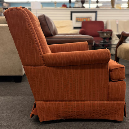 Ethan Allen upholstered armchair featuring rust-orange striped fabric, a button-tufted backrest, padded rolled arms, and a tailored skirted base.
