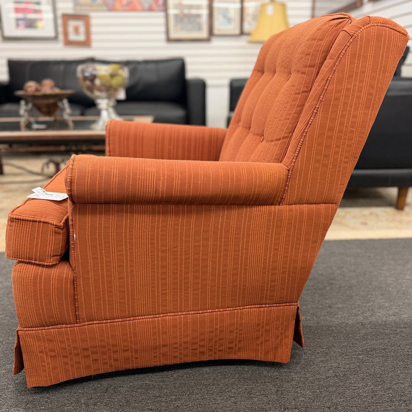 Ethan Allen upholstered armchair featuring rust-orange striped fabric, a button-tufted backrest, padded rolled arms, and a tailored skirted base.