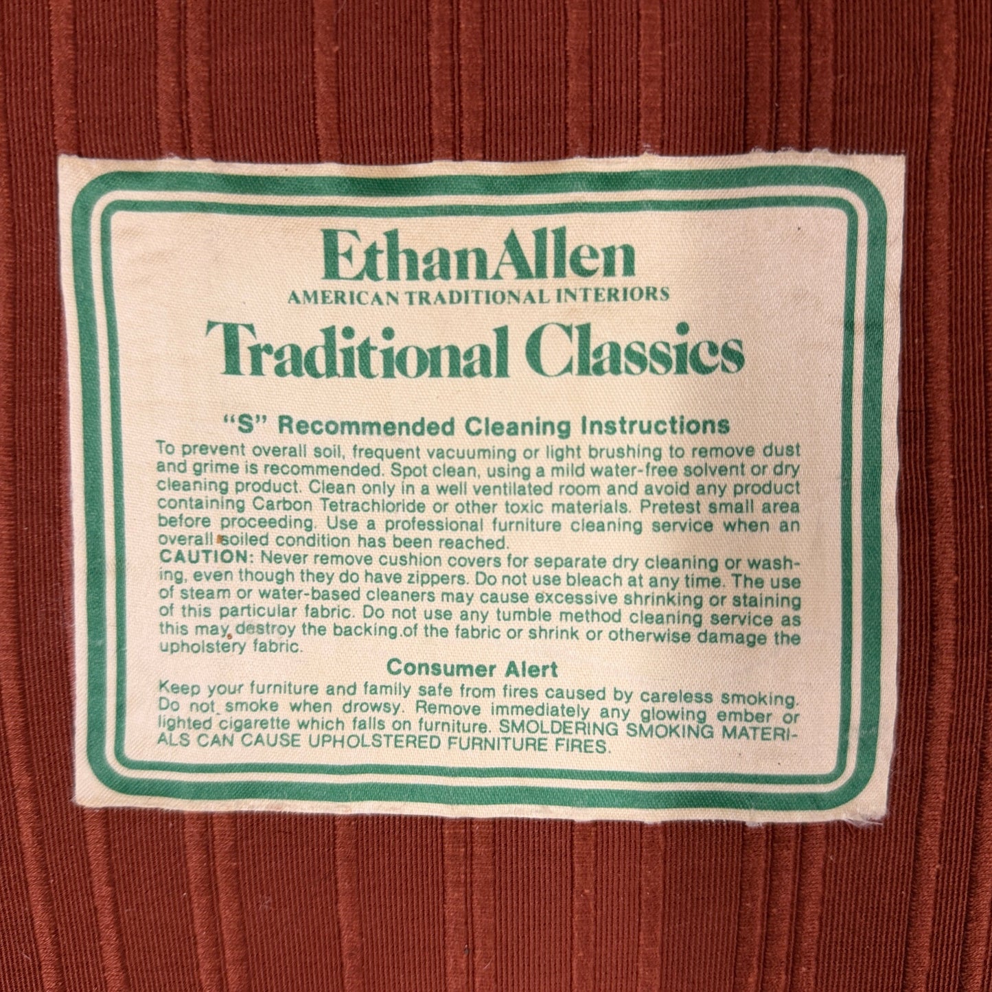 Ethan Allen upholstered armchair featuring rust-orange striped fabric, a button-tufted backrest, padded rolled arms, and a tailored skirted base.