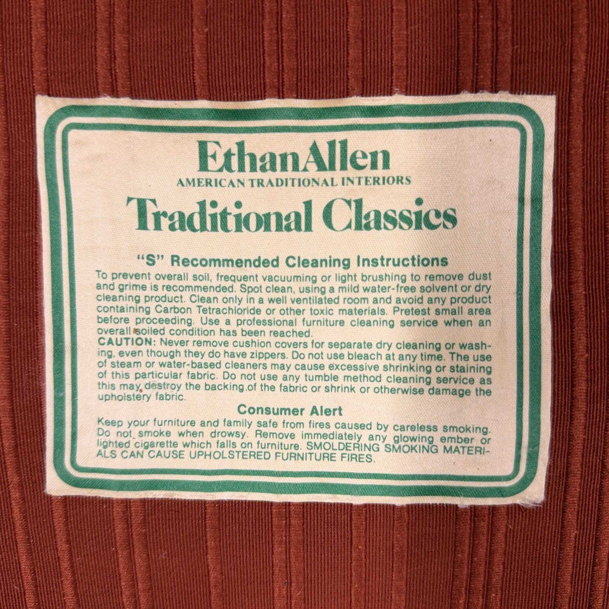 Ethan Allen upholstered armchair featuring rust-orange striped fabric, a button-tufted backrest, padded rolled arms, and a tailored skirted base.