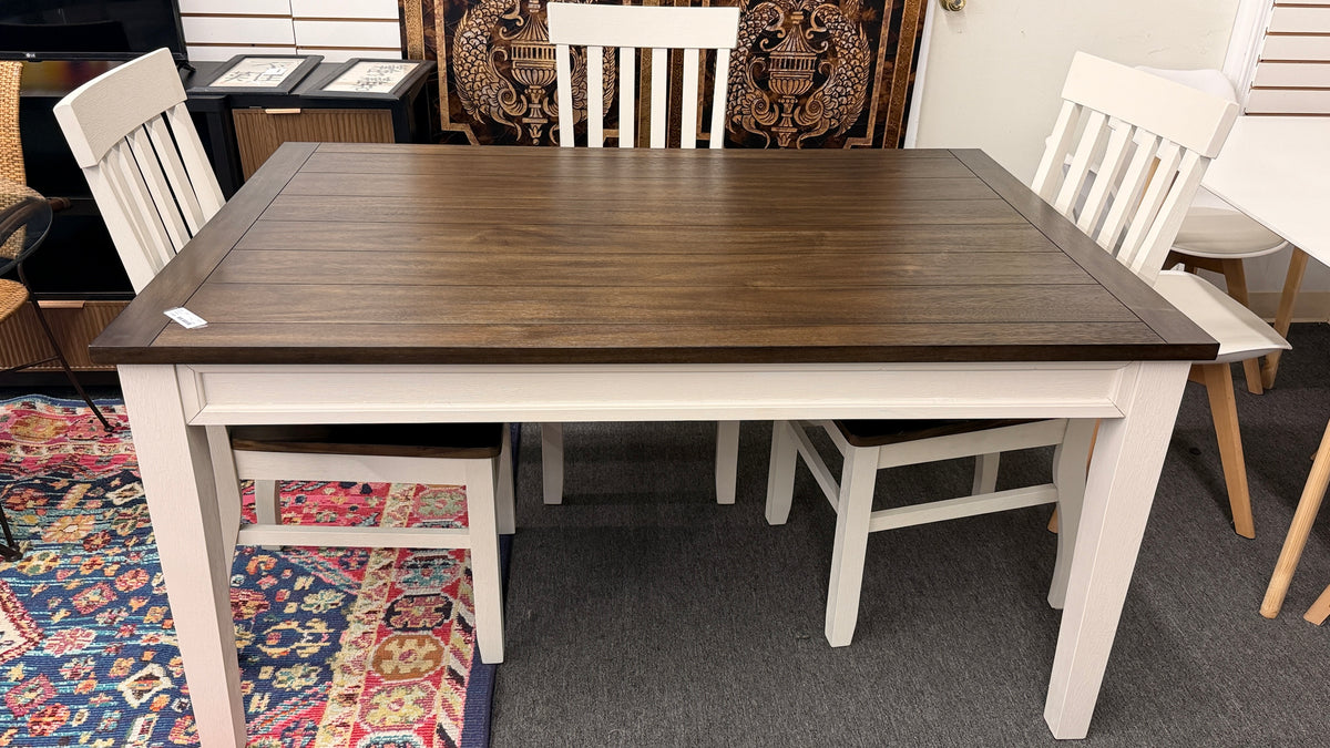 A farmhouse-style rectangular dining set with a dark-stained wood table top, antique white base, and four matching white slat-back chairs in excellent condition.