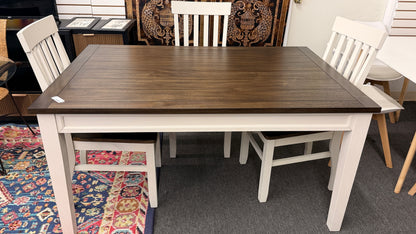 A farmhouse-style rectangular dining set with a dark-stained wood table top, antique white base, and four matching white slat-back chairs in excellent condition.