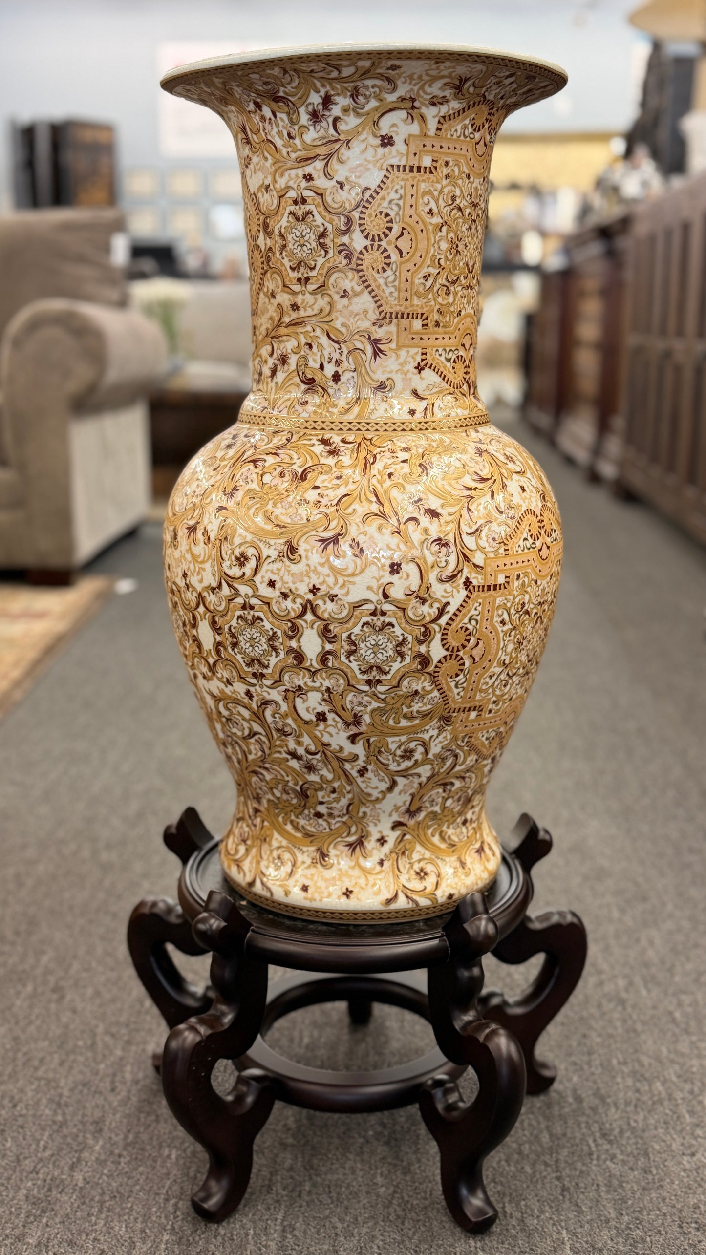 Traditional gold and brown filigree ceramic floor vase with intricate decorative patterns on a curved wood stand at 2nd Debut Houston consignment showroom