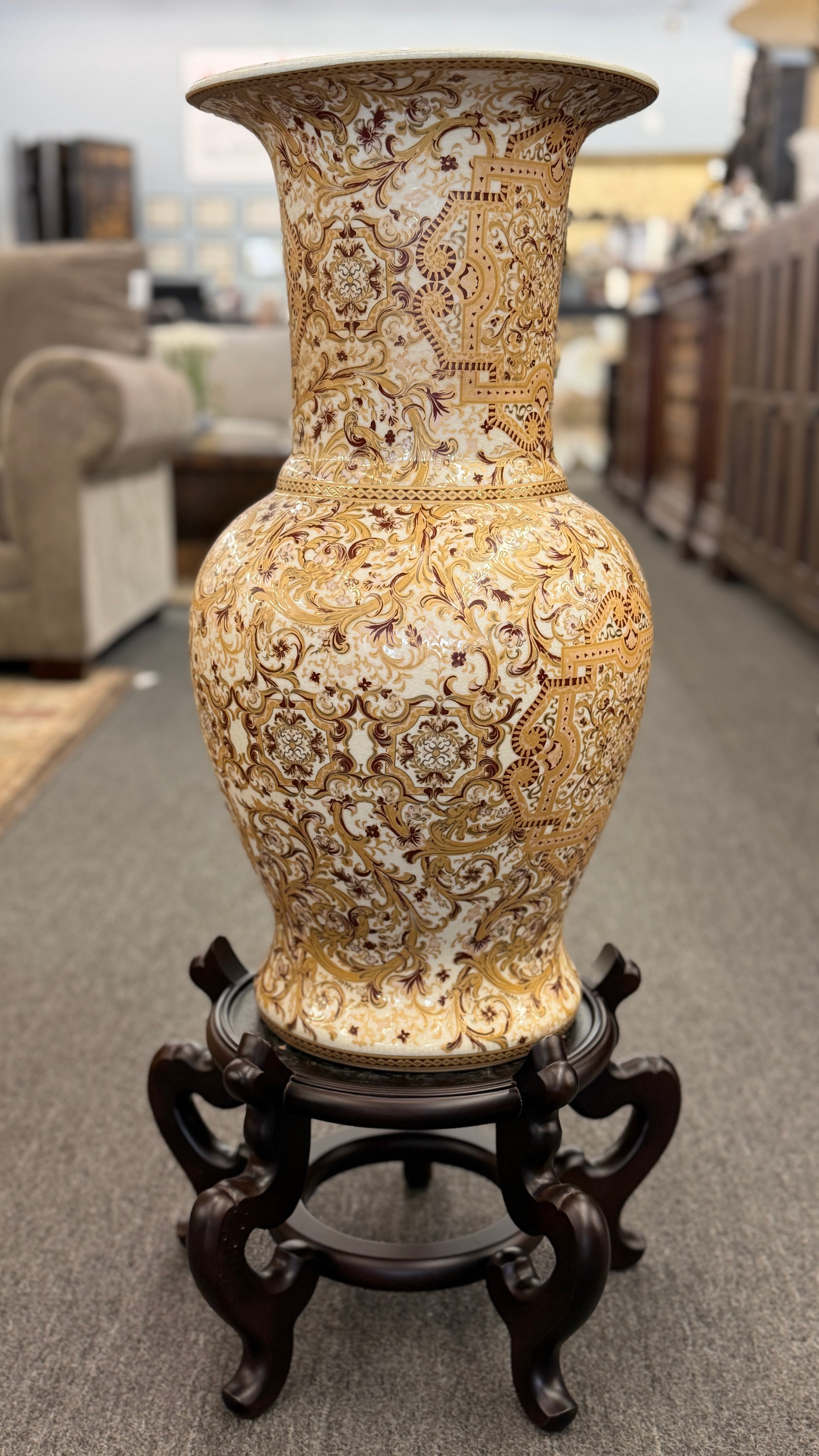 Traditional gold and brown filigree ceramic floor vase with intricate decorative patterns on a curved wood stand at 2nd Debut Houston consignment showroom