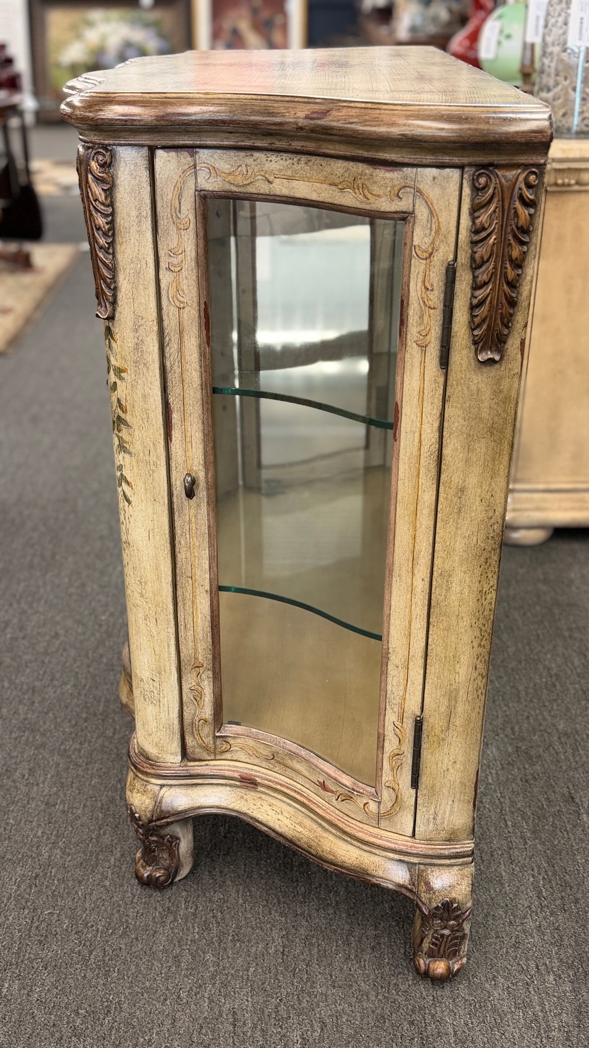 A French Provincial style three-door curio cabinet featuring a distressed antique cream finish, curved glass panels, and carved cabriole feet in excellent condition.