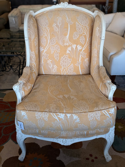 An elegant French provincial-style wingback armchair with an ornate carved white wood frame, tufted-style high backrest, loose seat cushion, and curved cabriole legs.