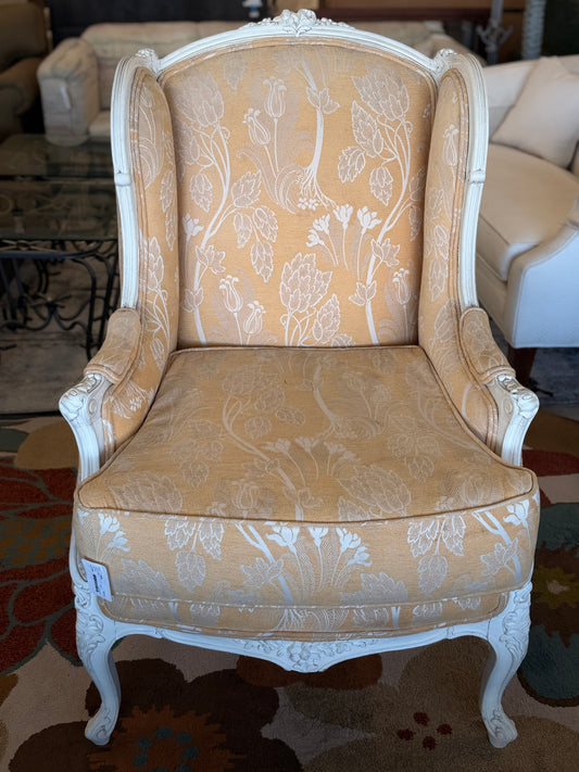 An elegant French provincial-style wingback armchair with an ornate carved white wood frame, tufted-style high backrest, loose seat cushion, and curved cabriole legs.