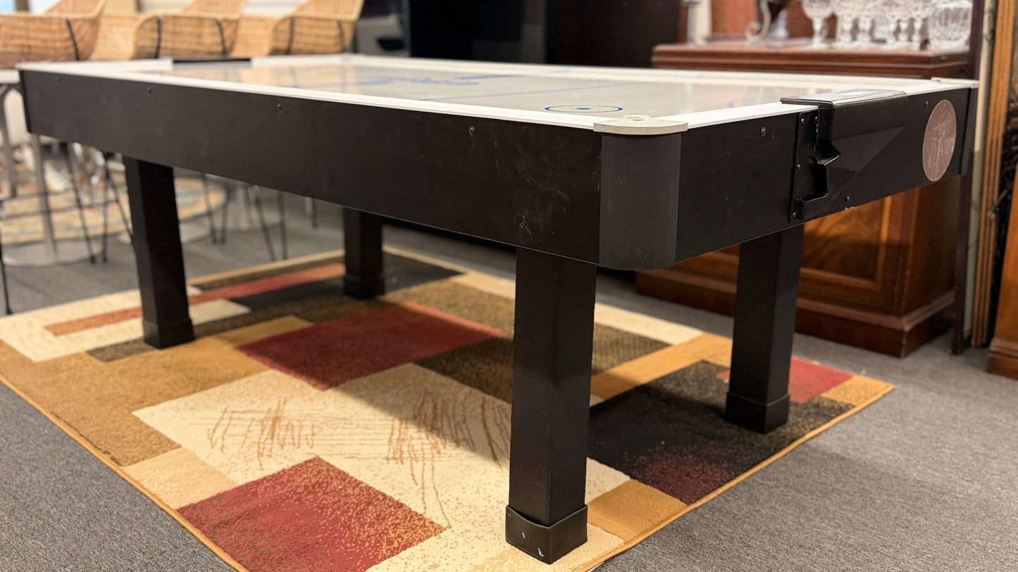 Full-size air hockey table with a white playing surface, blue boundary lines, sturdy black frame, and durable legs for home game room entertainment.
