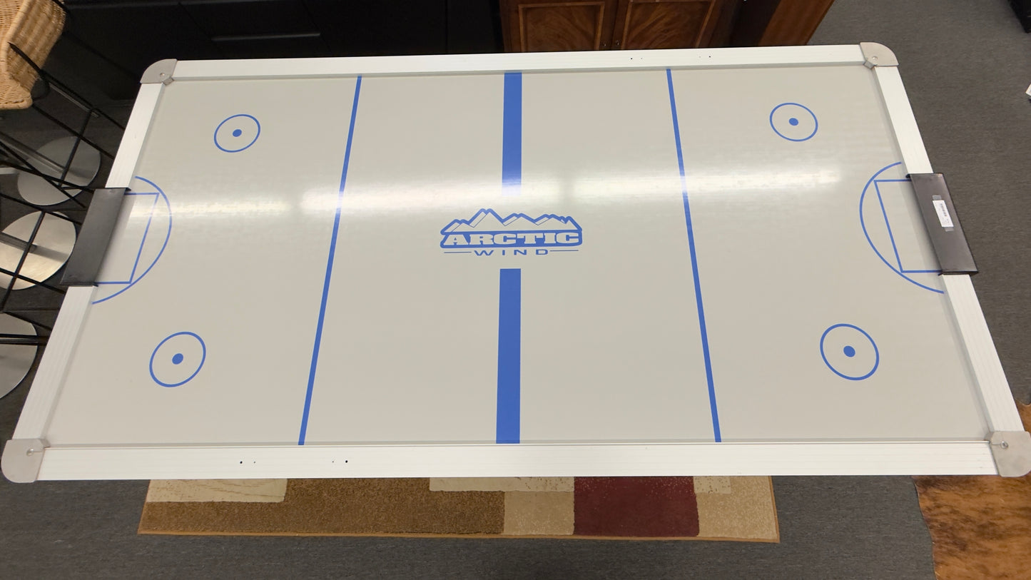 Full-size air hockey table with a white playing surface, blue boundary lines, sturdy black frame, and durable legs for home game room entertainment.