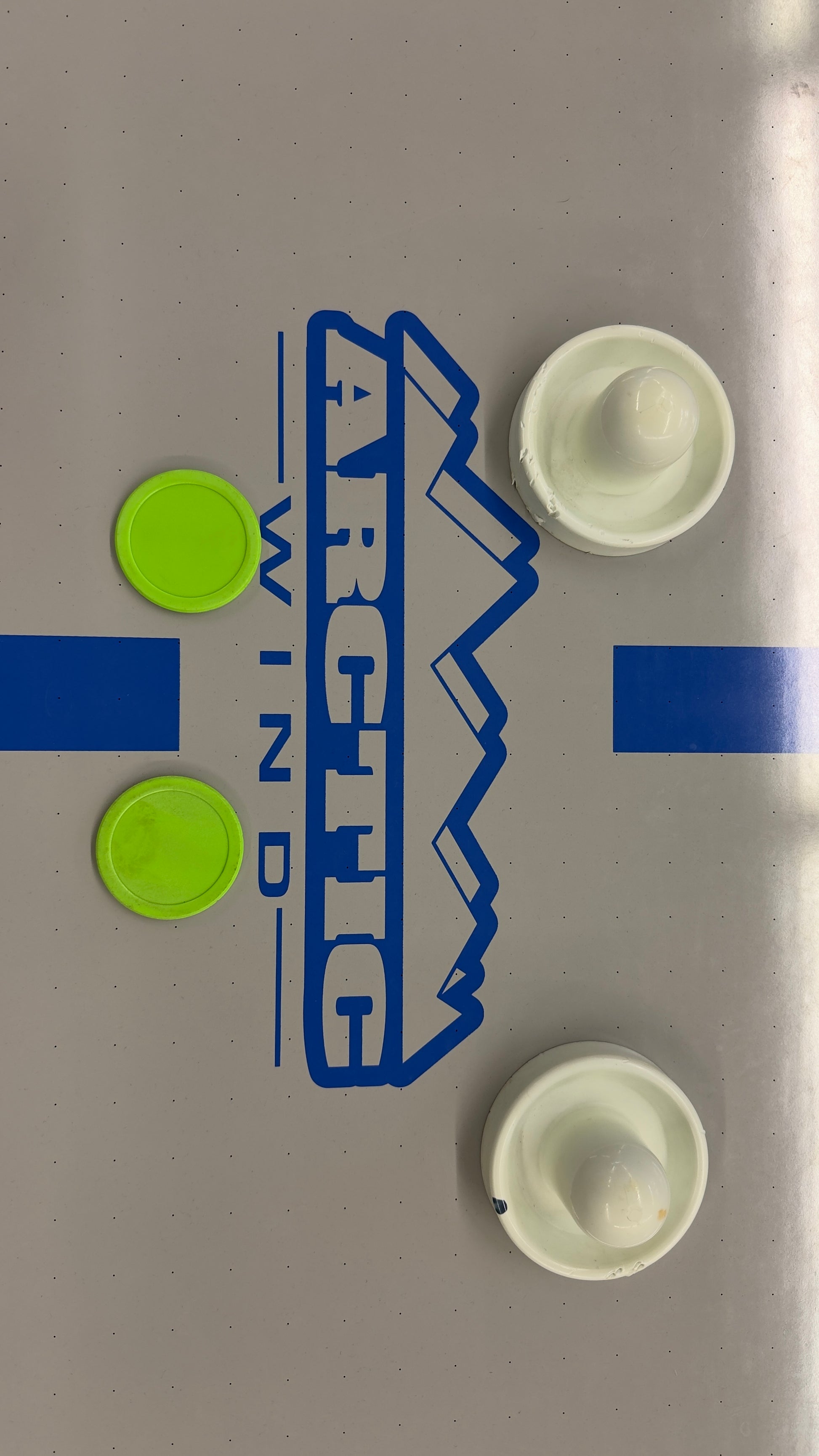 Full-size air hockey table with a white playing surface, blue boundary lines, sturdy black frame, and durable legs for home game room entertainment.