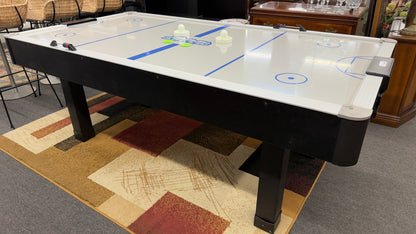 Full-size air hockey table with a white playing surface, blue boundary lines, sturdy black frame, and durable legs for home game room entertainment.
