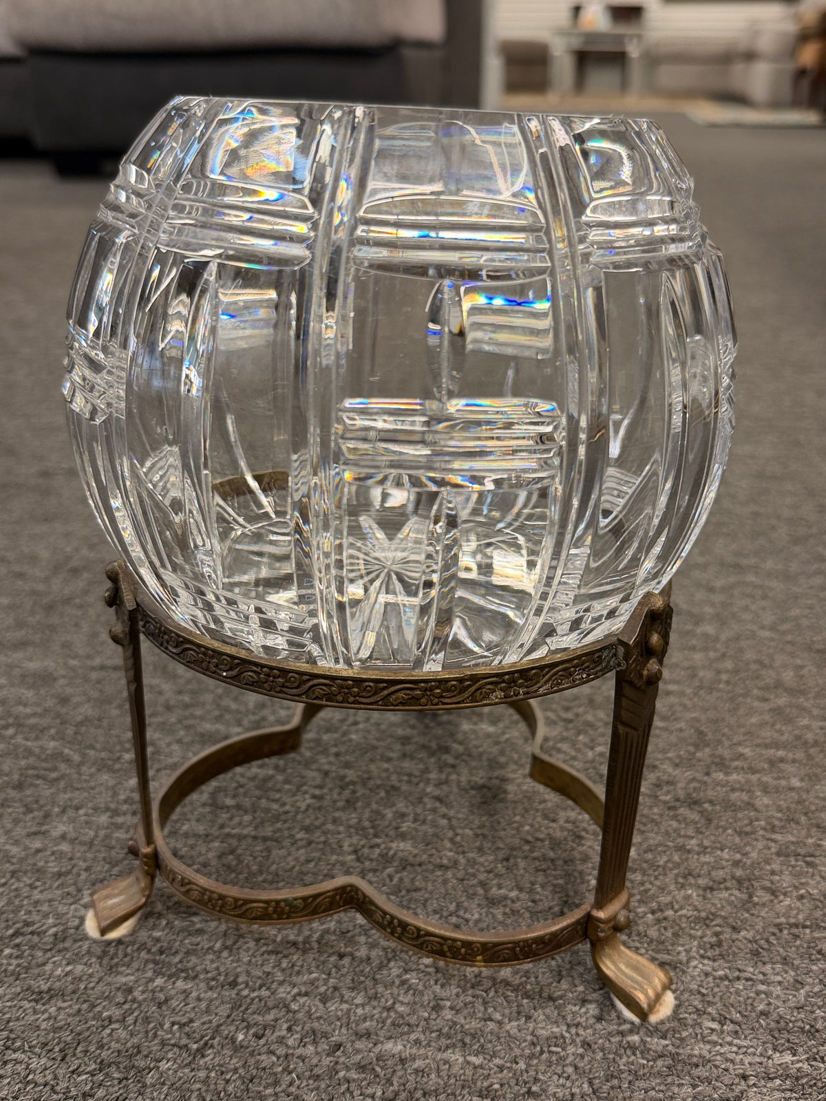 A geometric cut-crystal bowl set on an ornate antique brass-finished tripod stand in excellent condition.
