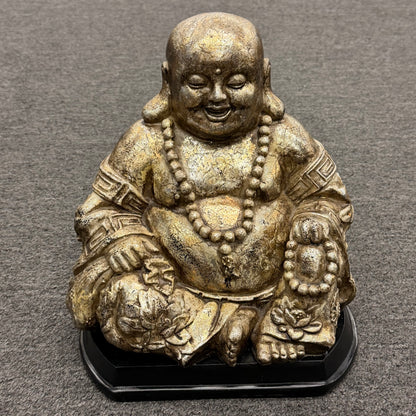 Classic gold-tone seated laughing Buddha synthetic decorative figurine against a gray background at 2nd Debut Houston consignment showroom