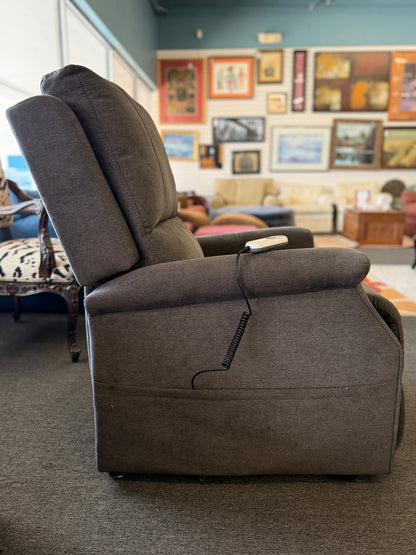 A standard upholstered recliner chair in a solid grayish-brown fabric featuring a structured paneled backrest and padded armrests.