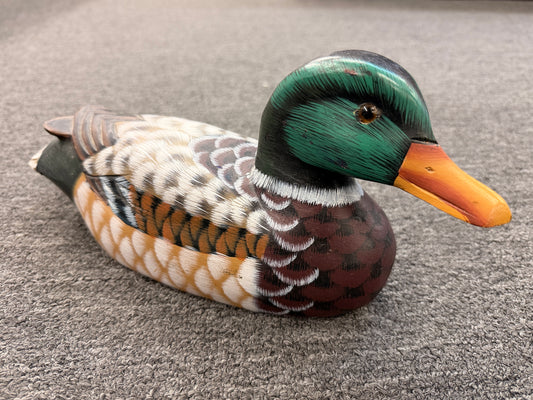 A hand-painted decorative wooden mallard duck decoy featuring detailed feather patterning and glass eyes in excellent condition.