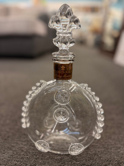 An iconic collector's glass decanter featuring ribbed side flanges, raised medallions, and a Fleur-de-lis crystal stopper in excellent condition.