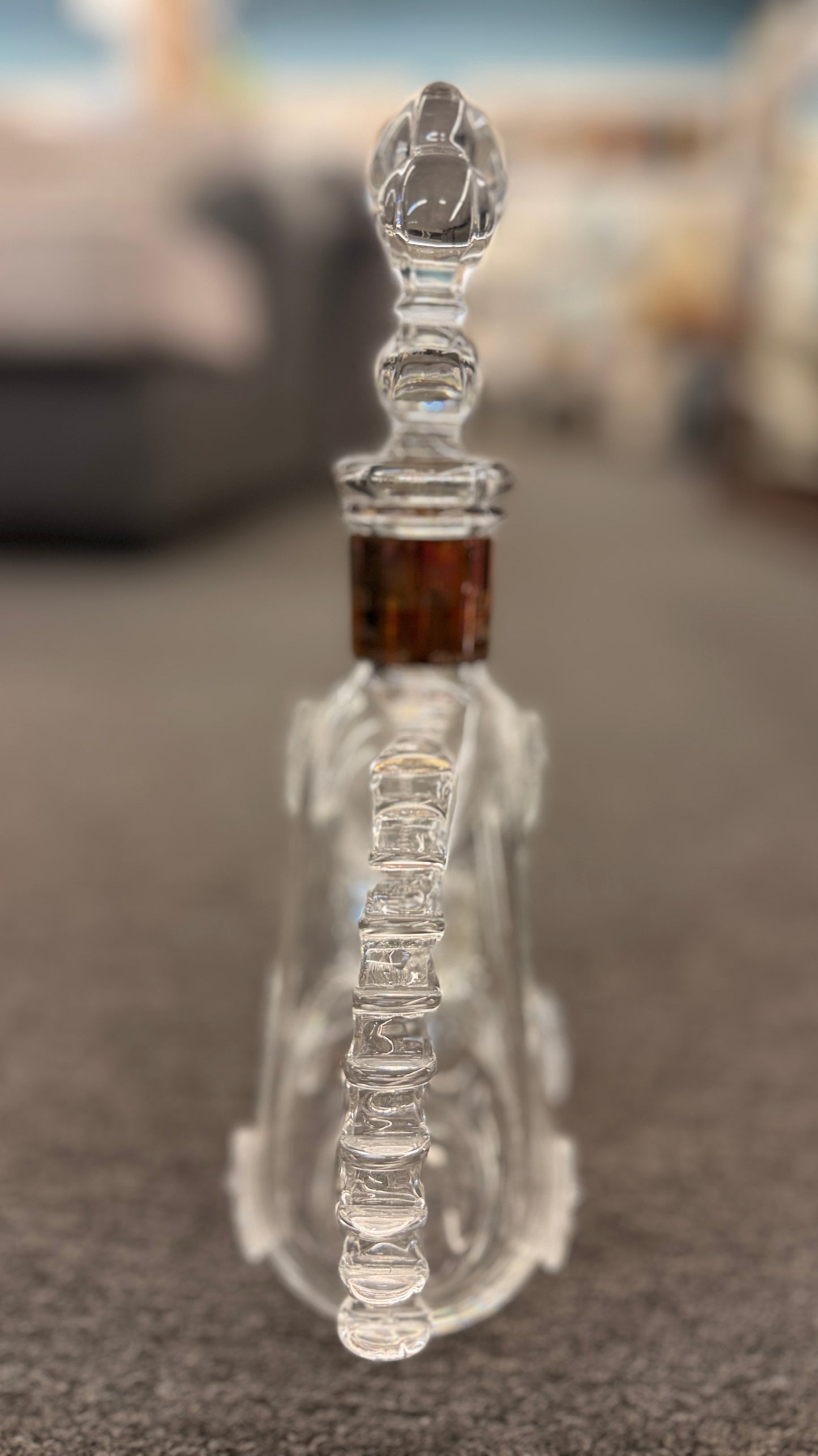 An iconic collector's glass decanter featuring ribbed side flanges, raised medallions, and a Fleur-de-lis crystal stopper in excellent condition.
